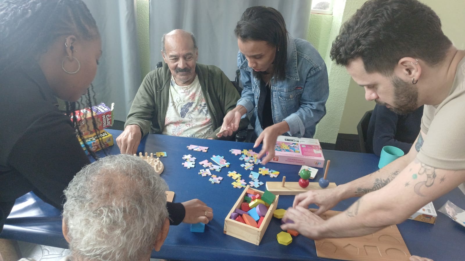 Residentes em atividade de quebra-cabeças com cuidadores